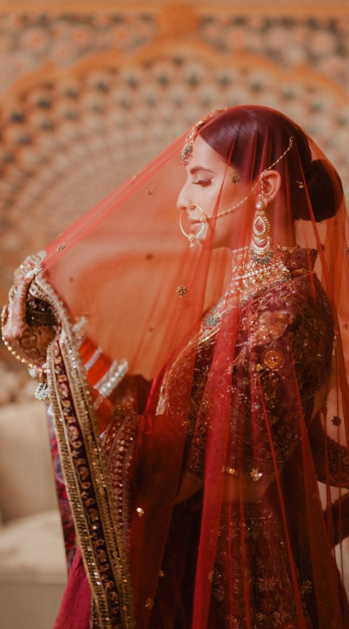 Punjabi bride practicing wedding photo poses in front of a mirror to capture her best angles
