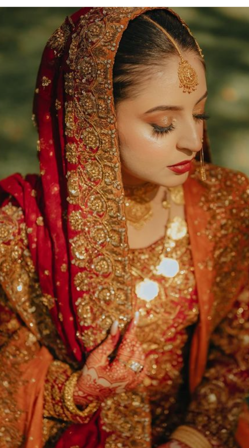 Punjabi bride posing for wedding photos during golden hour with soft, natural lighting