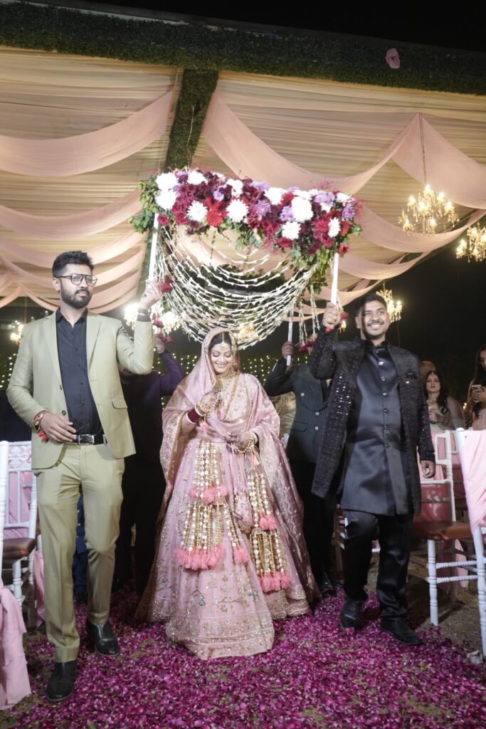 Bride making her bridal entry during a Punjabi wedding in Mohali wearing a dusty pink lehenga with long kalire

